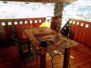une table et des chaises en bois sur une terrasse en bois dans l'établissement Appartamento Sole, à Morgex