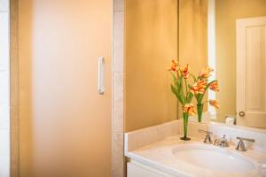 a bathroom with a sink with a vase of flowers at Catherine Ward House Inn in Savannah