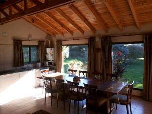 Una cocina y un comedor con mesa y sillas de madera. en Cabaña de Encanto, en San Rafael