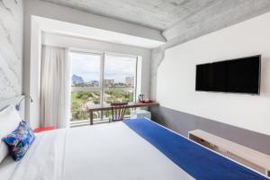 Ribalta Hotel Barra da Tijuca by Atlantica في ريو دي جانيرو: غرفة نوم بسرير كبير ونافذة كبيرة
