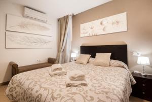 - une chambre avec un grand lit et 2 serviettes dans l'établissement Gades Suite, à Cadix