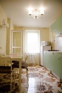 a kitchen with a table and a white refrigerator at Апартаменты посуточно in Sevastopol