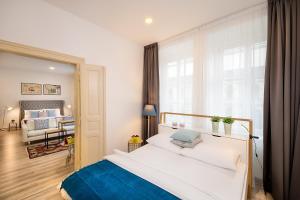 Luxurious Apartments Karlin في براغ: غرفة نوم بسرير ابيض كبير ونافذة