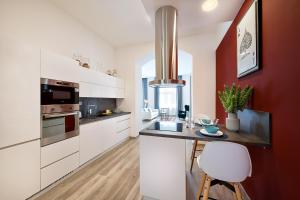 a kitchen with white cabinets and a counter top at Luxurious Apartments Karlin in Prague
