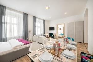 a white living room with a table and a couch at Luxurious Apartments Karlin in Prague