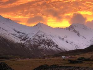 Hrafnavellir海如沃乐住宿加早餐旅馆的山地雪覆盖,背景是日落