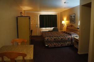 a hotel room with two beds and a table at Delux Inn Tulsa in Tulsa