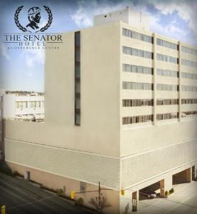 um grande edifício branco com um cartaz em The Senator Hotel & Conference Center Timmins em Timmins