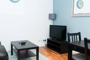 1BD Apartment in Dalston في لندن: غرفة معيشة مع تلفزيون وطاولة
