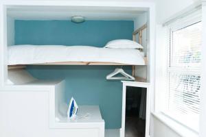 1BD Apartment in Dalston في لندن: غرفة نوم مع سرير بطابقين وجدار ازرق