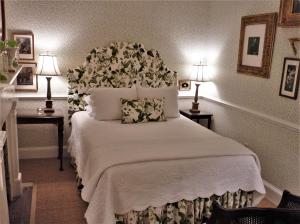 a bedroom with a bed with a white bedspread at Catherine Ward House Inn in Savannah