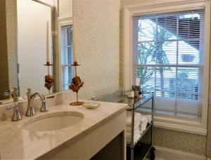 
a bathroom with a sink, mirror and bath tub at Catherine Ward House Inn in Savannah

