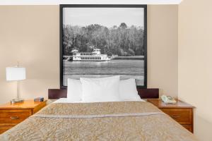 a bedroom with a bed and a boat on the water at Super 8 by Wyndham Clear Lake in Clear Lake