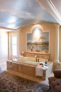 un ampio bagno con vasca e quadro di Summer Creek Inn a Rapid City