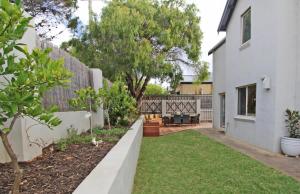 a backyard of a house with a fence and grass at Stones-Throw in Margaret River Town