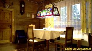 DzianiszにあるChata na Zagrodachのダイニングルーム(テーブル、椅子、シャンデリア付)