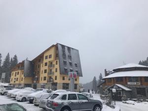 a parking lot with cars parked in front of a building at Apartment Love in Vlasic