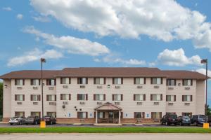 een groot gebouw met auto's geparkeerd voor het bij Super 8 by Wyndham Mason City in Mason City