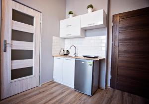 a small kitchen with a sink and a refrigerator at Apartamenty Nowy Rynek in Bydgoszcz