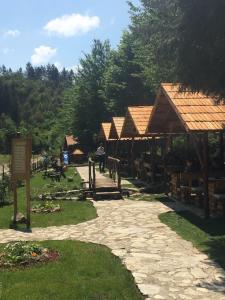 eine Gruppe von Pavillons mit Dächern und einem Steinweg in der Unterkunft Motel Stovrela in Cazin