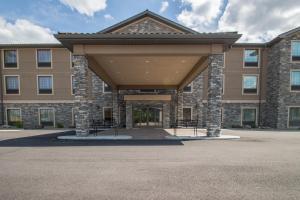 a large brick building with awning in front of it at Cobblestone Inn & Suites - St Marys in Saint Marys