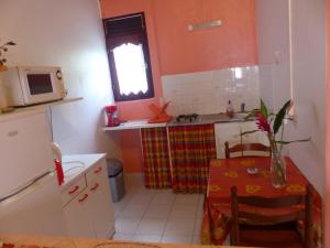a small kitchen with a table and a microwave at Chez L'habitant in Capesterre-Belle-Eau
