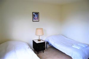 um quarto com 2 camas e um candeeiro numa mesa de cabeceira em Cabañas Del Hain em Ushuaia
