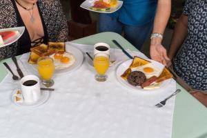 a table with plates of breakfast foods and glasses of orange juice at Catarata Eco Lodge in Fortuna