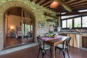 una cucina a pianta aperta con tavolo e sedie in legno di La Sassaia a Carmignano