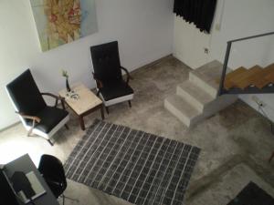 a room with two chairs and a table and stairs at Palermo Viejo Bed & Breakfast in Buenos Aires