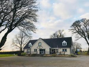 a white house with a black roof at Clogher Valley Golf Club in Fivemiletown