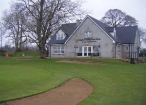 ein Haus mit grünem Rasen davor in der Unterkunft Clogher Valley Golf Club in Fivemiletown