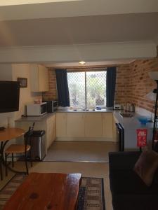 a kitchen with white cabinets and a large window at Paradise Apartment in Gosford