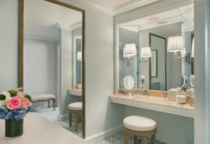 a bathroom with a mirror and a vanity with a sink at The Peninsula Beverly Hills in Los Angeles