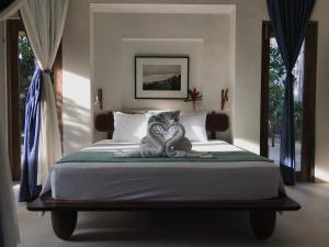 a bedroom with a large bed with blue curtains at Villa Samudera in Nusa Lembongan