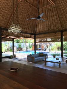 a living room with a couch and a ceiling fan at Villa Samudera in Nusa Lembongan