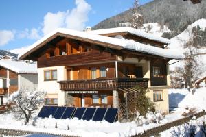 una casa en la nieve con un panel solar en Haus Mitti, en Heinfels