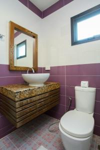 a bathroom with a toilet, sink, and mirror at PloyKhumThong Boutique Resort in Lat Krabang