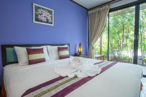 
a bed room with a white bedspread and pillows at PloyKhumThong Boutique Resort in Lat Krabang
