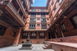 a building with a pillar in the middle of a courtyard at Kantipur Temple House in Kathmandu