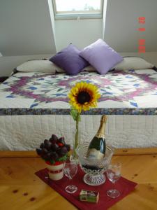 una mesa con una botella de vino y una flor en una cama en Breathtaking New Premier Lake Champlain Waterfront Escape!, en Addison