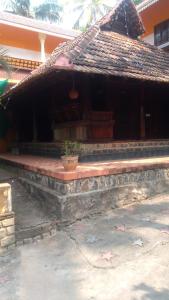 un bâtiment avec une terrasse couverte dotée d'une plante en pot dans l'établissement Thriphala Ayurveda Yogashram, à Trivandrum