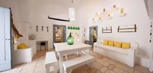 マルッジョにあるMasseria Scorcialupiの白いリビングルーム(白いソファ、テーブル付)