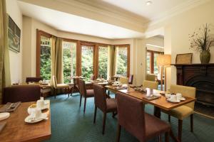 a dining room with tables and chairs and a fireplace at Franklin Manor in Strahan
