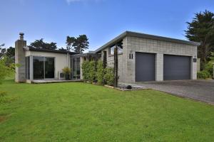 uma casa com duas portas de garagem num quintal em The Links Carters Beach Apartments em Carters Beach