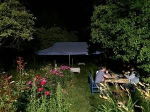 zwei Personen, die nachts an einem Tisch im Garten sitzen in der Unterkunft Hotel MIRA in Goris