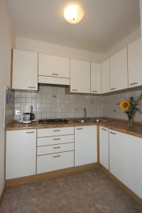 een keuken met witte kasten en een wastafel bij Paderlafoderhof in Laion