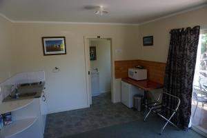 een keuken met een wastafel en een bureau in een kamer bij Abel Tasman Haven in Marahau