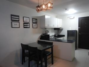 a kitchen with a table and a black counter top at Alta Cielo in The Courtyards Baguio in Baguio