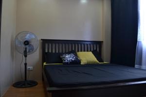 a bedroom with a bed with a fan and pillows at Alta Cielo in The Courtyards Baguio in Baguio
